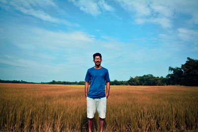 Man standing on field against sky