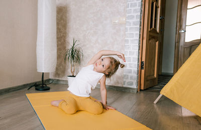 Girl sitting on wooden floor at home