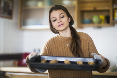 Young woman baking cookies in the kitchen