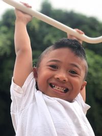Portrait of smiling boy hanging on rod