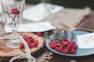 Raspberries in plate on table