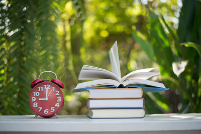 Close-up of alarm clock and books on table