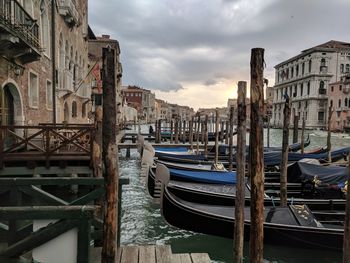 Boats moored in canal against buildings