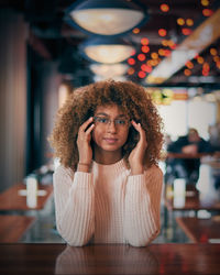 Portrait of smiling young woman sitting at home