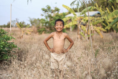 Portrait of smiling young woman standing on field