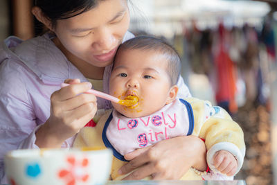 Portrait of cute baby boy having food outdoors