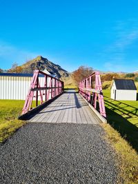 Lifeguard hut on field against clear blue sky
