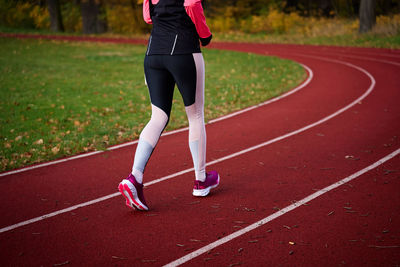 Low section of athlete running on treadmill outdoors