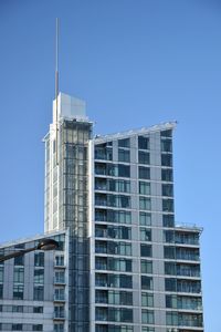 Low angle view of modern buildings against clear blue sky