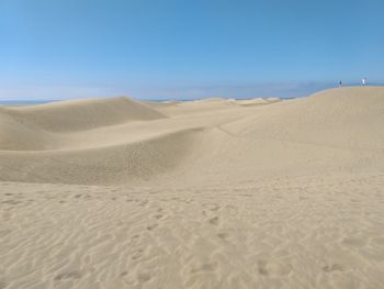 Scenic view of desert against clear blue sky