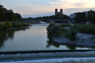 Arch bridge over river against buildings