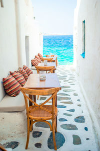 Chairs and table at beach against sky