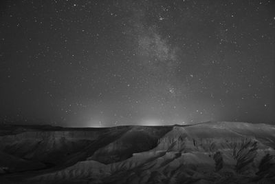 Scenic view of snowcapped mountains against sky at night