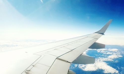 Cropped image of airplane against blue sky