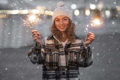 Portrait of smiling young woman standing on snow