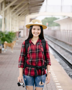 Portrait of woman standing by railroad tracks