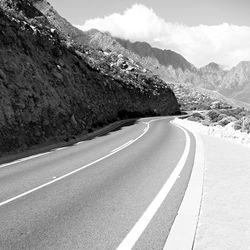 Road by mountains against sky