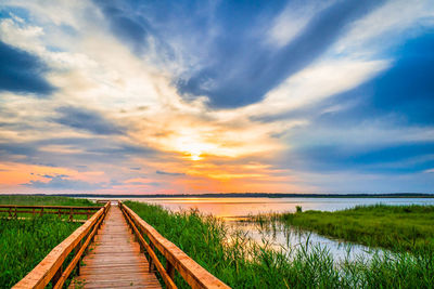 Walkway path in the lake. boardwalk, wooden bridge for nature trail. beautiful sunset.