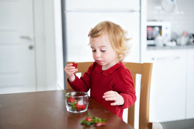 Cute little baby girl,toddler,pretty,infant eating strawberry.funny child,kid healthy lunch,berries
