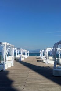 View of airport by sea against clear blue sky