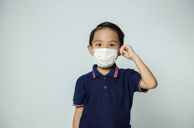 Portrait of boy standing against white background