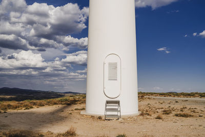 Lower part of wind turbine by cloudy sky