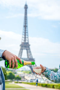 Bottle and glass of champagne on the background of the eiffel tower.