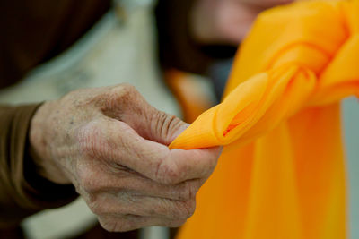 Close-up of hand holding orange textile