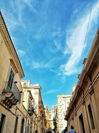 Low angle view of buildings against cloudy sky