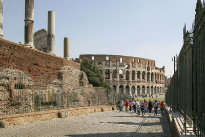 People walking by historical building