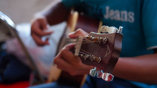 Midsection of man playing guitar