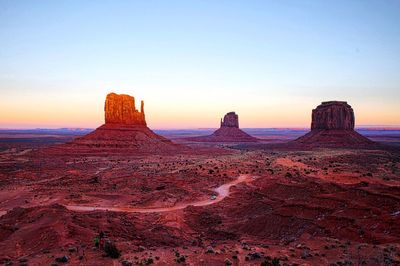 Rock formations at monument valley against sky during sunset