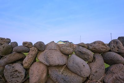 Stack of rocks on land against blue sky