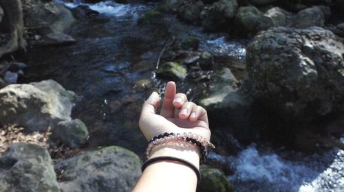 Close-up of woman hand on rock