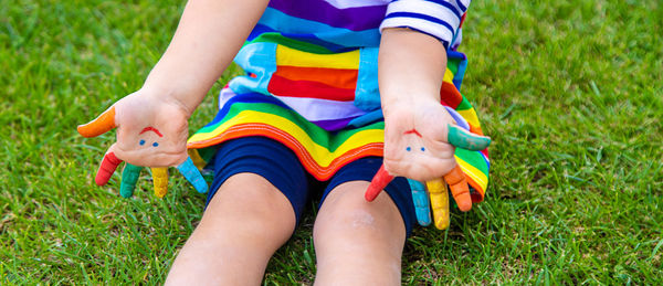 Low section of baby boy sitting on grass