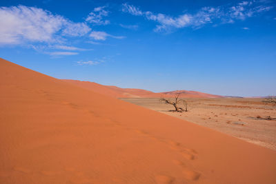 Scenic view of desert against blue sky