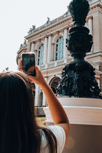 Rear view of woman photographing sculpture