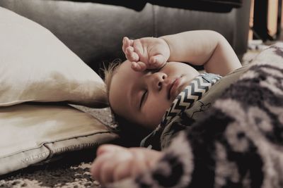 A small baby sleeps on the floor after a enjoying a fun afternoon play session.