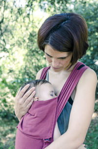 Portrait of young woman with daughter on tree