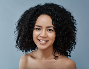 Portrait of young woman against blue background