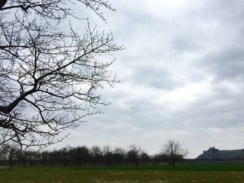 Scenic view of grassy field against cloudy sky