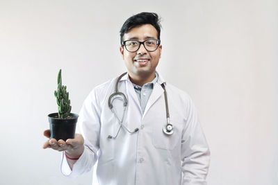 Mid adult man wearing eyeglasses standing against white background