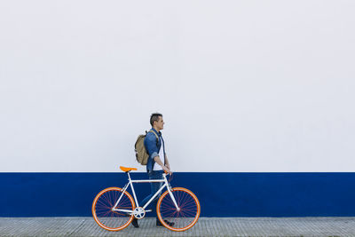 Man riding bicycle against wall