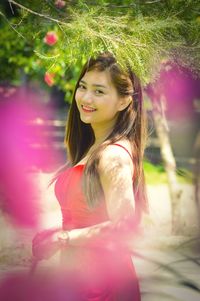 Portrait of smiling woman standing in park