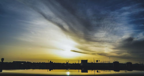 Silhouette buildings against sky during sunset