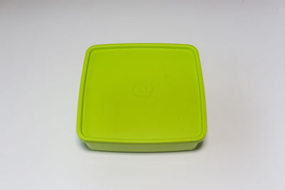Close-up of green yellow guitar against white background