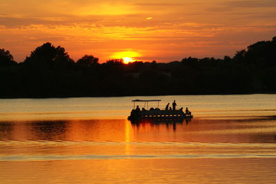Silhouette of boat in sea at sunset