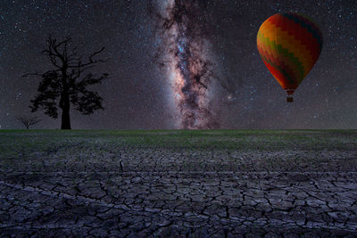 Digital composite image of hot air balloons on field against sky