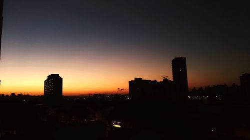 Silhouette buildings against sky during sunset