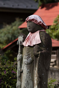 Close-up of statue against wooden post